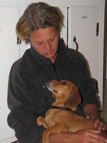 woman holding & comforting a dachsund on her lap