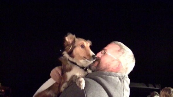 Daisy in arms of a neighbor who helped rescue her and her owner.