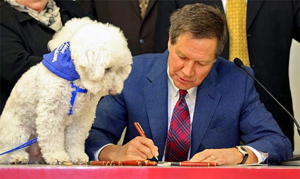 Barbara McKelvey came down for the event.  Her dog, Sammy, looks on as Ohio Governor John Kasich signs the bill into law.