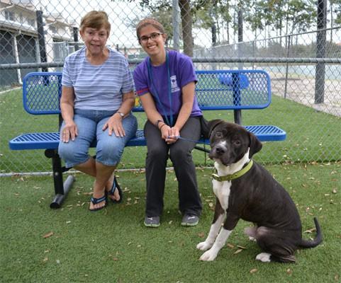 Ernie poses with his new mom and shelter volunteer. Photo Credit: Orange County Animal Services/Facebook