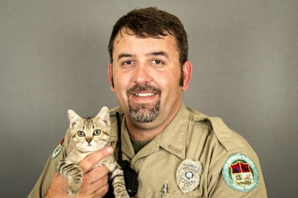 Animal control officer Randall Brown cuddles up with a shelter kitty named Muffin.