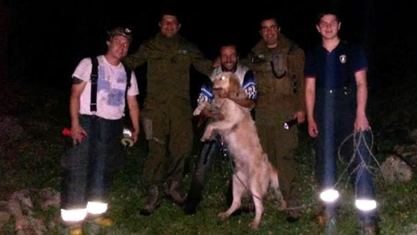 Firefighters pose with the pet and pet owner rescued from cliff.