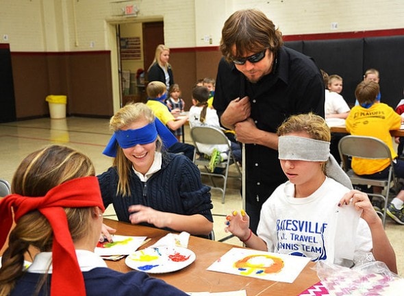 "Debbie Blank | The Herald-Tribune John Bramblitt encourages seventh-graders Jayden Rose (left) and Lily Esser. The artist also mentored students at Batesville primary, intermediate and high schools during a visit organized by the Rural Alliance for the Arts for its Arts in Education Program."
