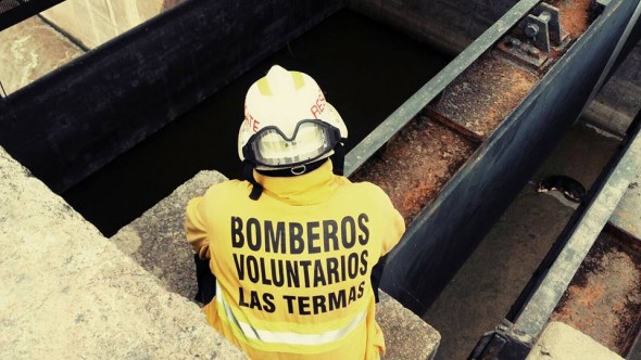 Firefighter plans how to rescue stray dog. Photo credit: Bomberos Voluntarios Las Termas/Facebook